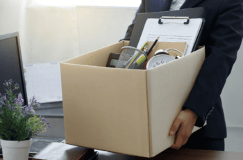 Woman carrying box after being dismissed from employment