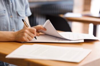 A person signing employment contracts with a pen